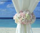 Цветочное украшение на шторах свадьбы на пляже